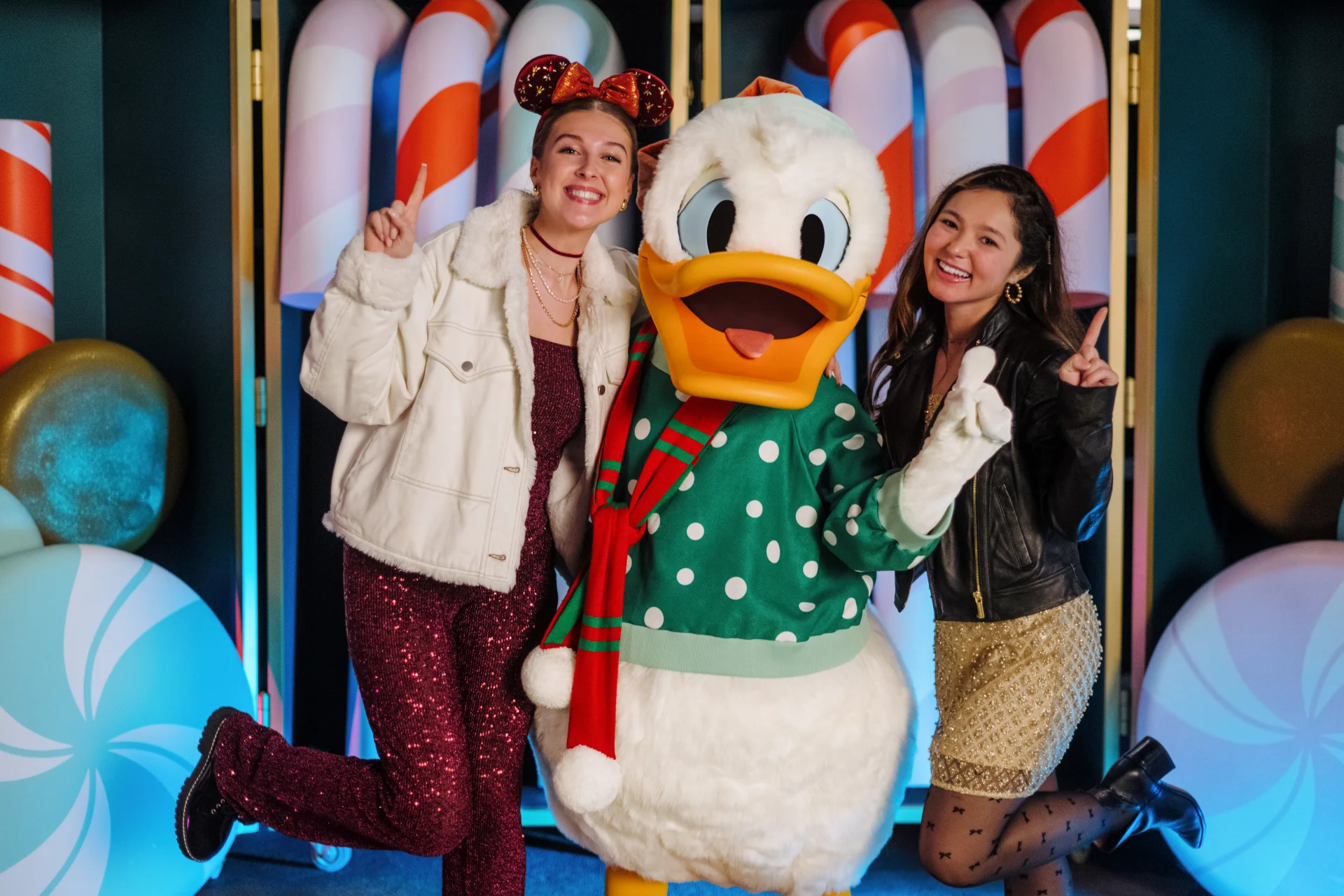 Donald Duck meeting guests in a holiday sweater at Disney Jollywood Nights