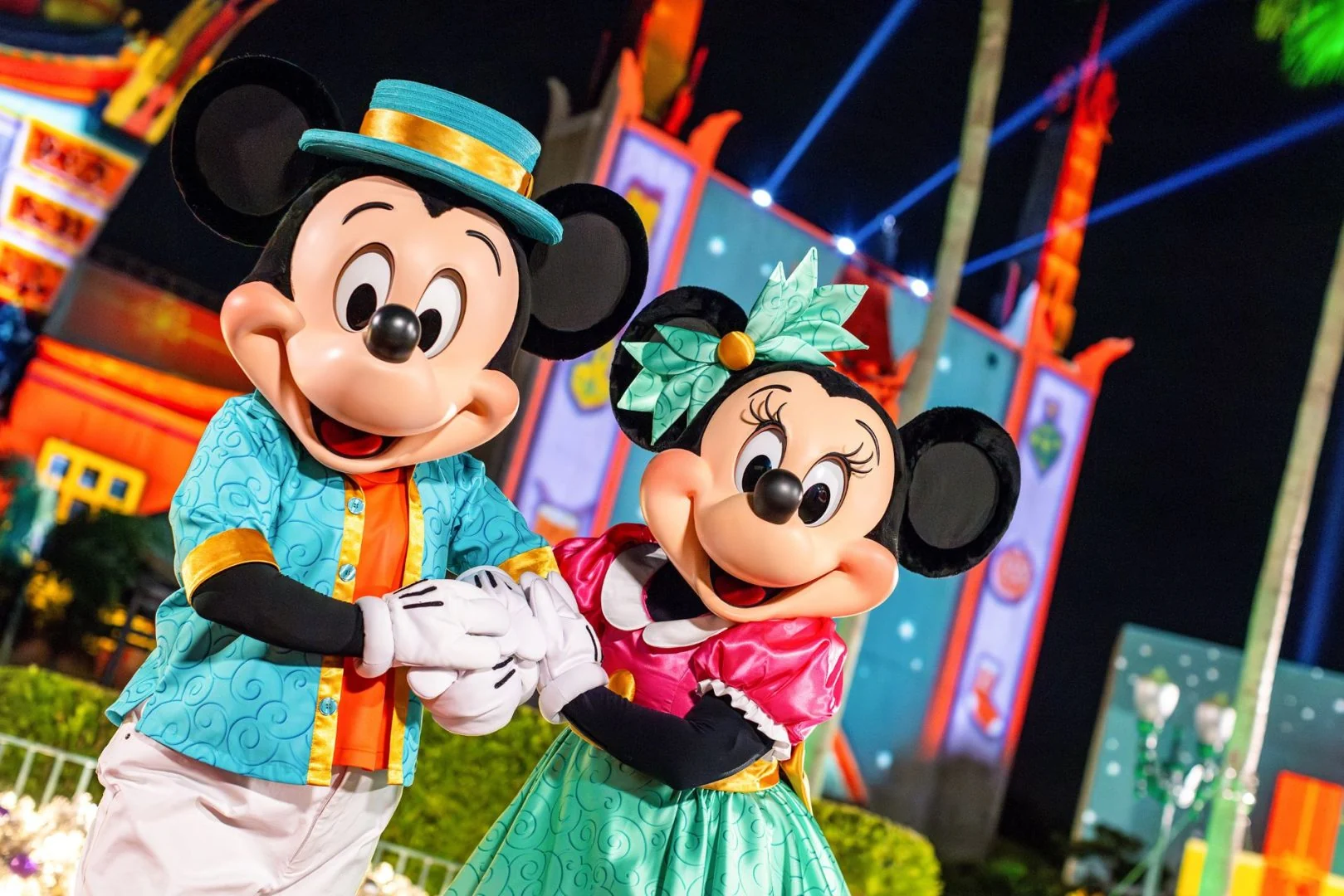 Mickey Mouse and Minnie Mouse wearing colorful outfits at Disney Jollywood Nights